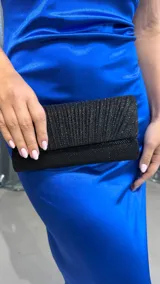 Cartera de mano tipo sobre, color negro con textura plisada y detalles de glitter.