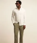 Pantalón de vestir color marrón, de corte recto, con bolsillos laterales y traseros. Se ajusta a la cintura con cinturón de cuero marrón.