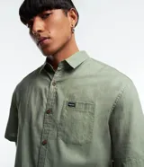 Camisa relaxed de manga corta para hombre, confeccionada en cáñamo y algodón. Tiene cuello inglés, abotonado delantero, bolsillo en el pecho y etiqueta de la marca.
