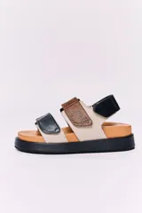 Sandalias de cuero color beige con base de goma color caramelo y suela negra. Presentan dos tiras horizontales, una de cuero negro y otra de cuero con textura de piel de serpiente en tonos marrones.
