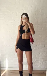 Body negro con escote asimétrico y aberturas en el abdomen.