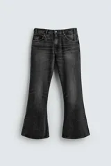 Pantalón de jean negro con efecto lavado, corte flare, tiro medio, cinco bolsillos y bajo irregular.