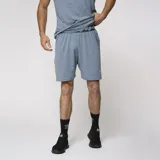 Bermuda deportiva azul con cintura elástica con diseño geométrico, detalle de línea amarilla en el lateral y logo de la marca en la pierna izquierda.