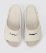 Sandalias Rider modelo Slide Drip, color beige, con logo de la marca en el frente.