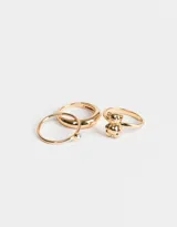 Set de tres anillos dorados de metal. Uno con forma de oso, otro liso y otro con strass.
