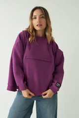 Buzo verde oscuro de corte recto y amplio, con capucha con cordones regulables y bolsillo frontal con cierre.