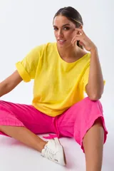 Blusa amarilla de viscosa, con escote redondo y mangas cortas con dobladillo.