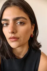 Aros de acero quirúrgico hipoalergénico con piedras naturales azules. Diseño de aro con dije circular colgante.