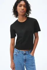 Remera negra de punto fino, con cuello redondo y mangas cortas.