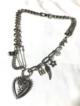 Collar de cadena de acero inoxidable plateada con dijes colgantes de acero y aleación: corazón radiante, candado, ala, estrella, pin de gancho y bola. Largo de 45cm regulable.