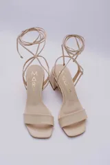 Sandalias rojas de cuero con tiras finas para atar al tobillo y tacón cuadrado.