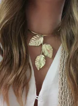 Gargantilla dorada con tres dijes colgantes en forma de hoja.