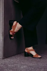 Sandalias de cuero color marrón con tiras cruzadas y taco bloque negro.