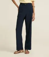 Pantalón de vestir azul marino, de corte recto, con bolsillos laterales y traseros. Se ajusta a la cintura con cinturón de cuero marrón.