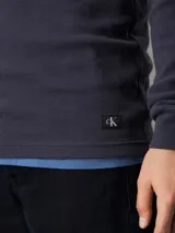 Remera de manga larga de punto gofrado azul marino, confeccionada en algodón regenerativo.