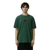 Remera de algodón color verde oscuro con efecto lavado, corte holgado y un pequeño logo ovalado bordado en rojo en el pecho.