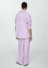 Camisa oversize lila con rayas verticales, de manga larga con puños abotonados, cuello camisero y dos bolsillos de parche en el pecho.