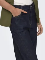 Pantalón de jean azul oscuro, de pierna ancha y tiro alto, con bragueta de botones, dobladillo doblado y pasadores para cinturón.