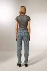 Pantalón de jean celeste con diseño de líneas curvas bordadas y strass. Corte recto y tiro alto.