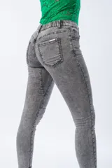 Pantalón chupín gris de tiro alto, confeccionado en algodón, poliéster y lycra.