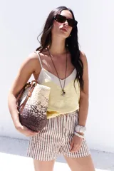 Musculosa de tirantes delgados con diseño bicolor: la parte superior es de color crema y la parte inferior es de color rosado pálido, ambas con acabado satinado.