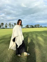 Zapatillas bajas con estampado animal print de vaca en blanco y negro, con cordones marrones y suela color caramelo.