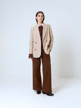 Blazer gris con finas rayas verticales, de corte clásico, con solapas de muesca, cierre frontal con dos botones y bolsillos con solapa.
