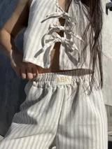 Pantalón largo de tiro alto con estampado a rayas verticales beige y blanco.