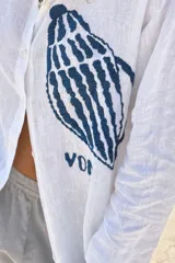 Camisa blanca de lino con bordado de pulpo azul en el pecho, de corte recto y manga larga.