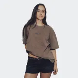 Remera de algodón color marrón con efecto gastado o acid wash, corte oversize y cuello redondo. Presenta un pequeño estampado en el pecho con la palabra "RELAJO".