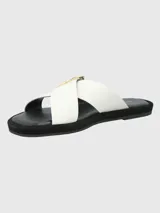 Sandalias de cuero sintético color blanco, con dos tiras anchas cruzadas sobre el empeine y hebilla circular dorada. Plataforma plana color negro.