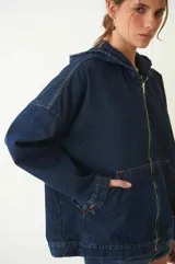 Campera estilo bomber de jean con canesú en la espalda, capucha, cierre metálico y dos bolsillos canguro en el frente.