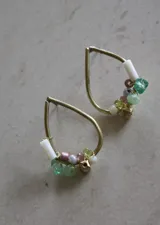 Aros colgantes dorados con forma de gota y cuentas de colores.