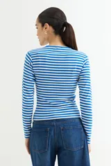 Remera de manga larga ajustada al cuerpo, con cuello redondo y estampado de rayas horizontales blancas y negras.