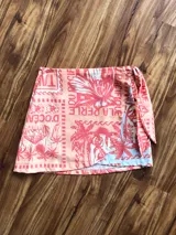 Minifalda pareo con estampado de motivos tropicales en tonos coral, rosa y celeste.