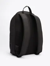 Mochila negra de poliéster con múltiples bolsillos, cierre de doble cremallera, asa superior, correas ajustables y acolchadas, compartimento principal, dos bolsillos interiores abiertos, bolsillo interior con cremallera, bolsillo exterior con cremallera y logo de Tommy Hilfiger en la parte delantera.