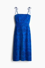Vestido midi azul con breteles finos con moño y escote recto. Tiene broderie floral calado en todo el vestido y ribete festoneado en el escote y el ruedo.