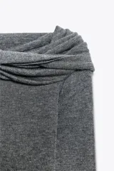 Jersey gris de punto con escote recto con vuelta y nudo delantero, hombros descubiertos y manga larga.