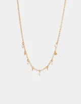 Collar corto dorado con cadena de eslabones y dijes colgantes de metal y perlas sintéticas.