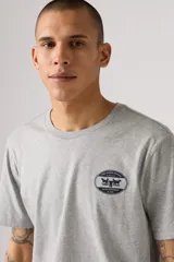 Remera gris de manga corta con cuello redondo y logo ovalado de Levi's estampado en el pecho.