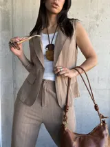 Chaleco sastrero color tostado con rayas verticales finas, escote en V y cierre frontal con botones.