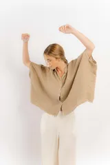 Camisa color beige de lino con mangas amplias y cinta en tono más oscuro.