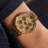 Reloj Guess dorado con esfera brillante y patrón de peonías estampado en la lente.