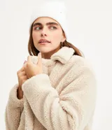 Saco alargado color beige de sherpa con cuello solapa, manga larga y abotonado delantero.