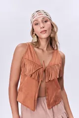 Chaleco color ladrillo con flecos en el pecho y lazo de ajuste en el centro.