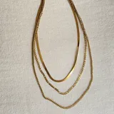 Collar dorado de triple cadena con dije de estrella.