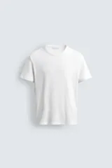 Camiseta blanca de corte slim fit, confeccionada en tejido de algodón con elasticidad. Tiene cuello redondo y mangas cortas con terminación en rib.