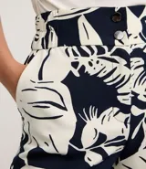 Short de corte sastrero con cintura alta y estampado tropical. Presenta cierre frontal con doble abotonadura.