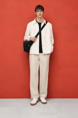 Pantalón color beige de popelina de algodón, corte ancho, con cintura elástica ajustable con cordón, bolsillos laterales y traseros.