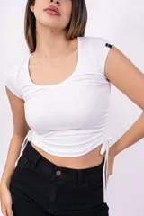 Remera negra de corte crop con escote redondo y mangas cortas. Presenta cordones ajustables en los laterales.